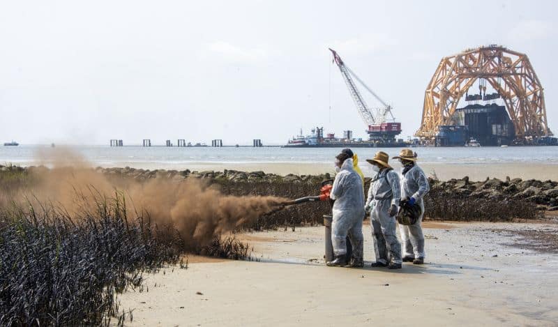 Lundi, une équipe de nettoyage du rivage applique de la mousse de sphaigne sur l'herbe des marais pétrolifères près de l'accès à la plage publique de la rue Wylie.  La mousse de sphaigne est un revêtement adsorbant naturel qui favorise le processus naturel de dégradation du pétrole tout en réduisant la probabilité de transfert de pétrole à la faune.  |  Crédits image : réponse à l'incident de St. Simons Sound