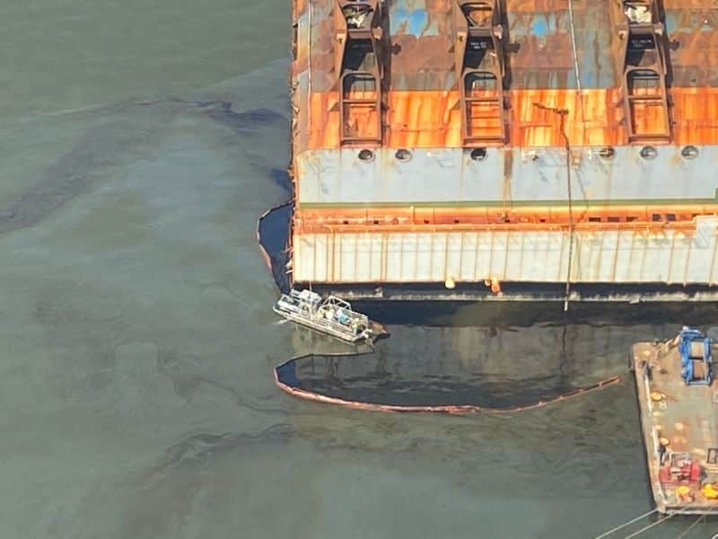 Un navire écrémeur de pétrole MARCO s'attache au barrage de rétention autour du reste de l'épave du Golden Ray afin d'éliminer le pétrole retenu à l'intérieur du barrage lundi.