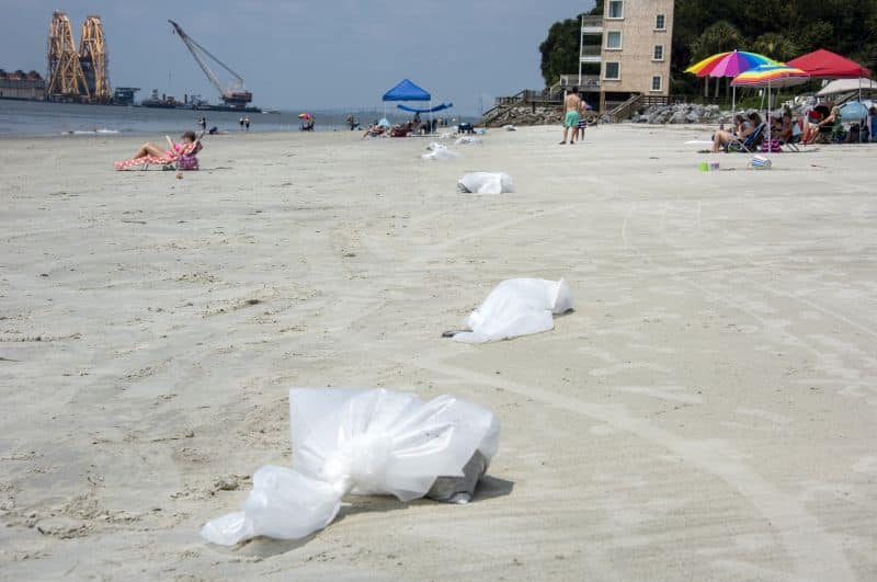 Des sacs de sable huilé attendent le ramassage par les équipes de nettoyage du rivage près de l'accès à la plage de la 11e rue lundi.
